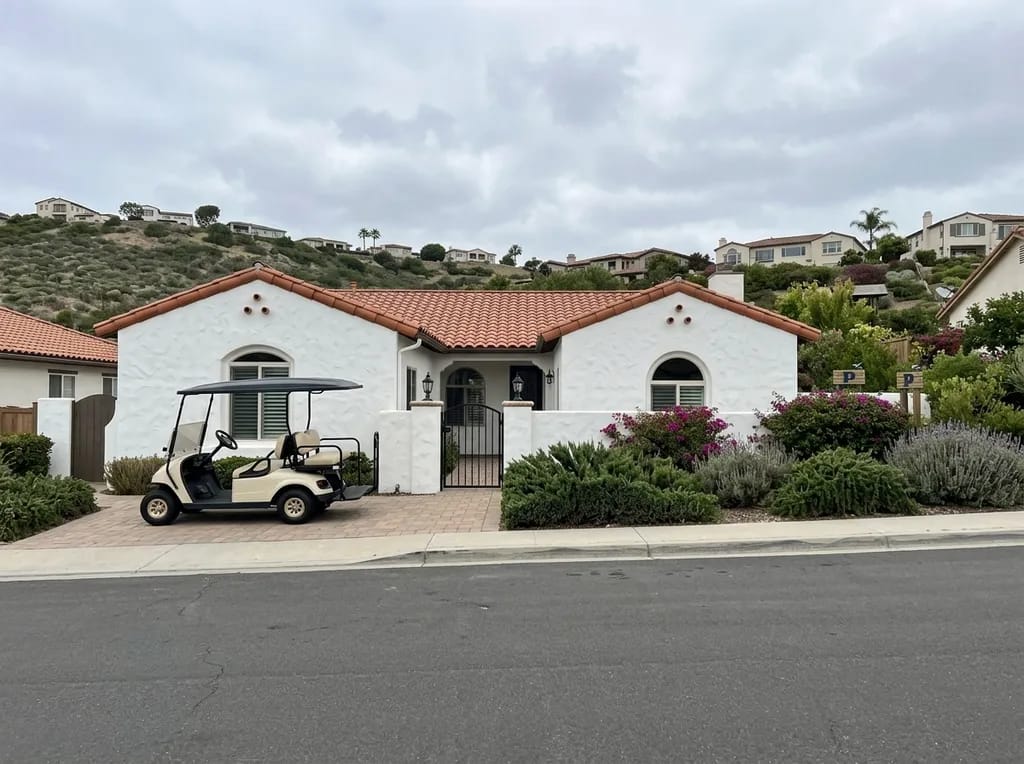 Single-story white stucco home with a golf cart in the driveway in Ocean Hills, Oceanside